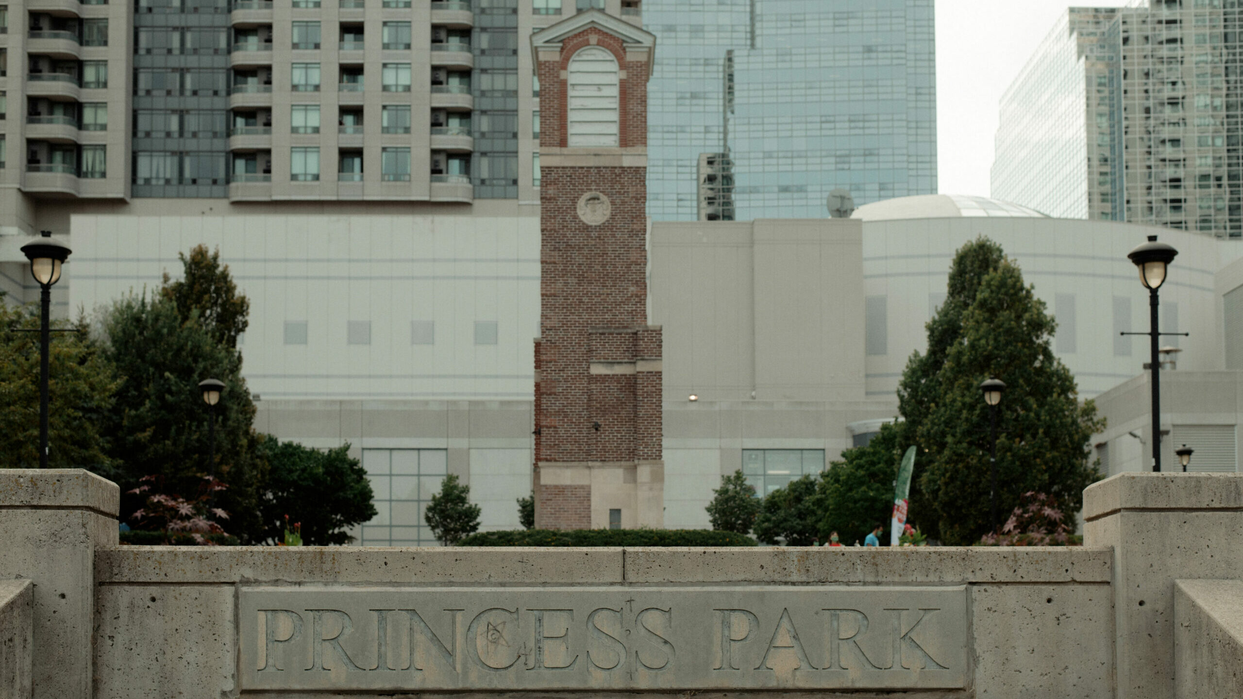 A large stone tower against a background of buildings. A stone sign in front reads "Princess Park".
