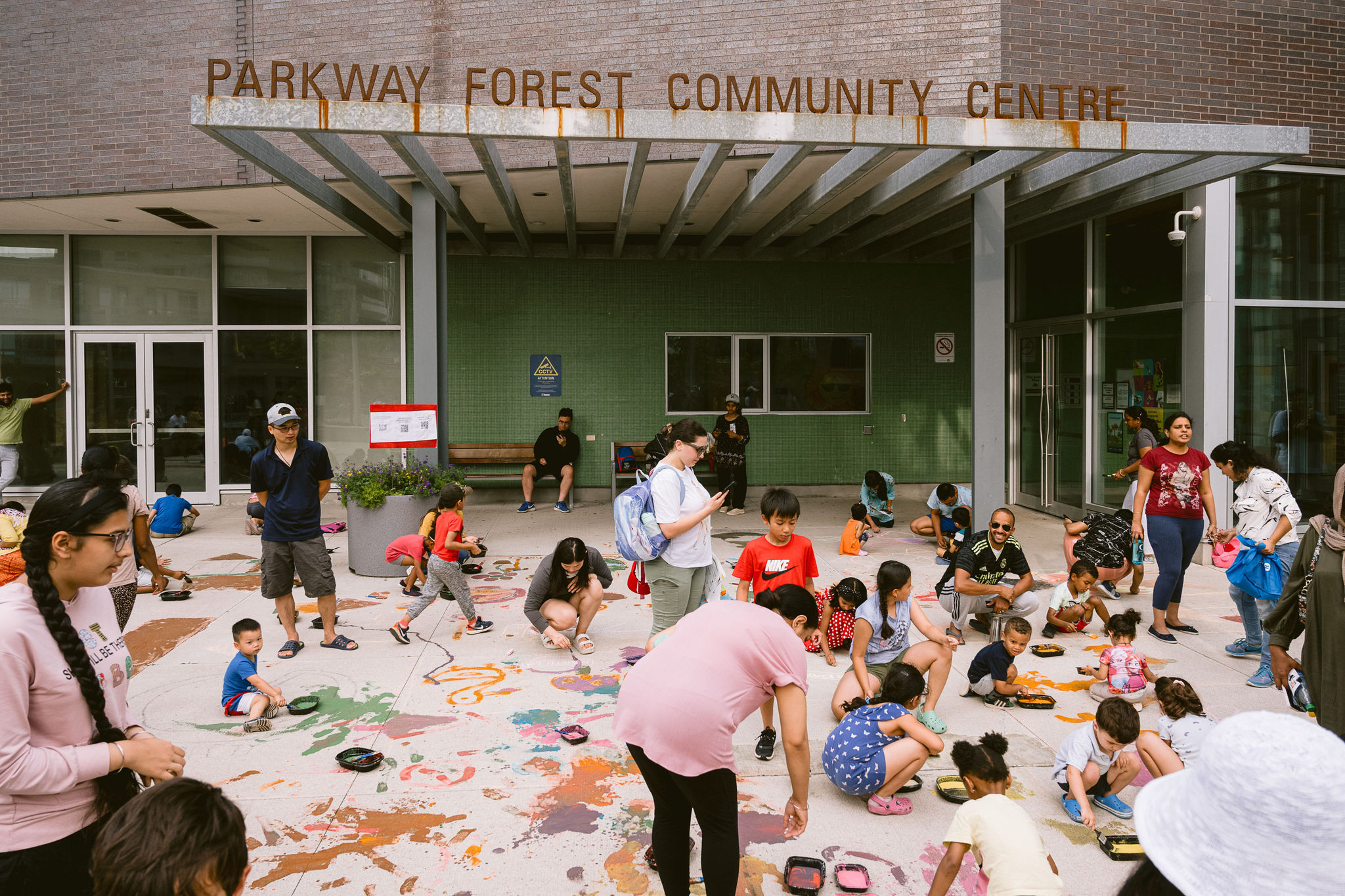 A diverse group of participants painting the ground at Parkway Forest Park.